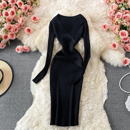 Schwarzes Strickkleid, langärmelig, figurbetont, auf weißem Fell, umgeben von rosa Rosen.