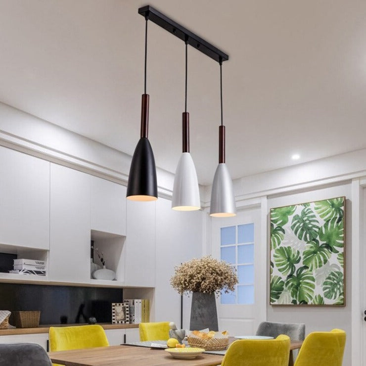 Moderne dreiflammige Pendelleuchte in Schwarz und Weiß über Esstisch, skandinavisches Design.