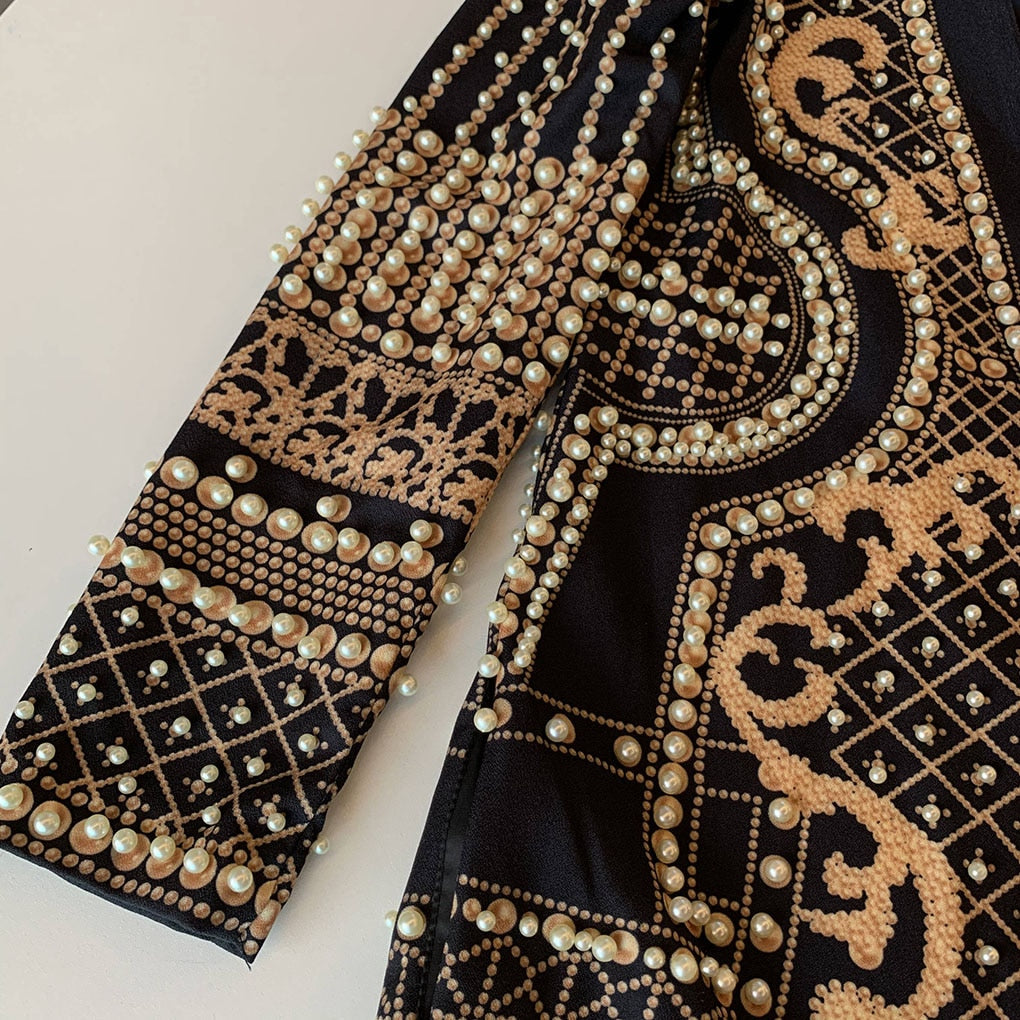 Schwarzes Kleid mit goldenen Perlenverzierungen, elegantes Design, Abendmode.