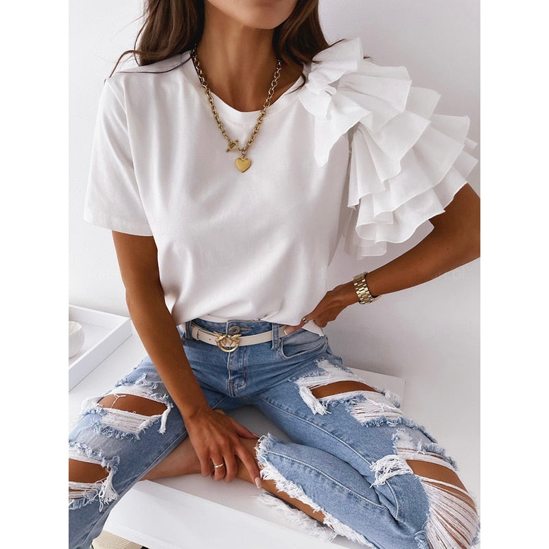Frau in weißem Rüschen-T-Shirt und zerrissener Jeans, modisches Outfit, lässiger Stil.