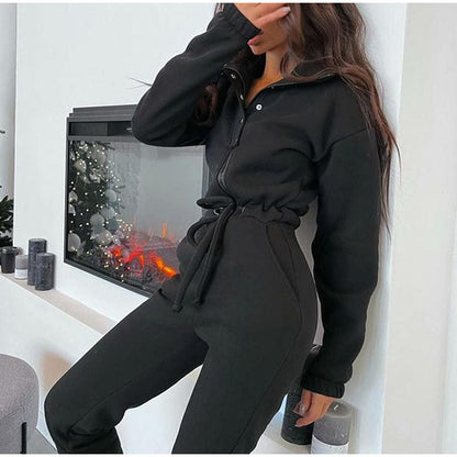 Frau in schwarzem Jogginganzug vor Kamin, gemütliche Wintermode, Freizeitkleidung Damen.