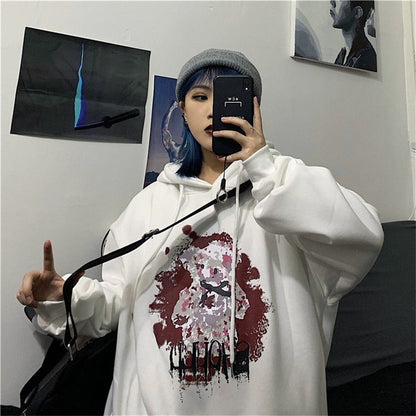 Frau in weißem Hoodie mit Kunstmotiv, graue Mütze, Selfie im Spiegel, urbaner Stil.