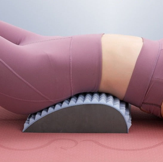 Frau in rosa Sportkleidung auf grauem Yoga-Rückenstrecker, Fitness, Dehnung, Entspannung.