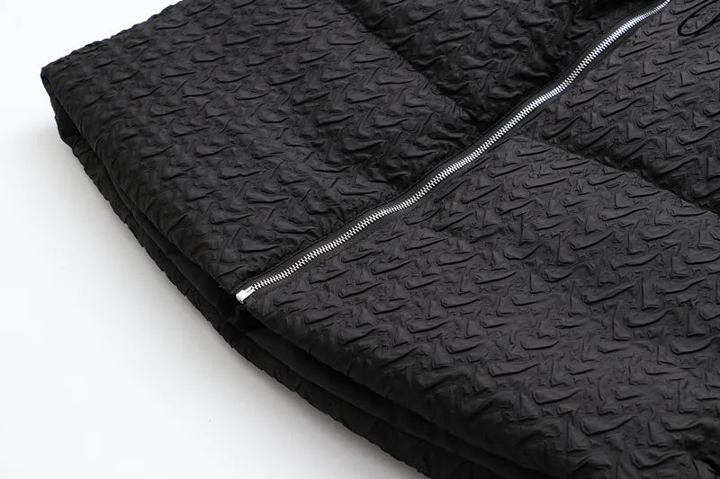 Schwarze gesteppte Jacke mit Reißverschluss, strukturierte Oberfläche, modisch, warm.