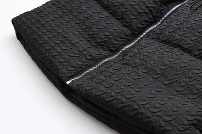 Schwarze gesteppte Jacke mit Reißverschluss, strukturierte Oberfläche, modisch, warm.
