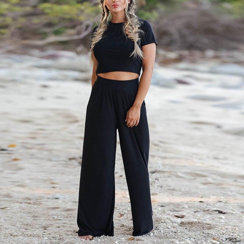 Frau in schwarzem, lässigem Zweiteiler-Set am Strand, Sommermode, Damenbekleidung.