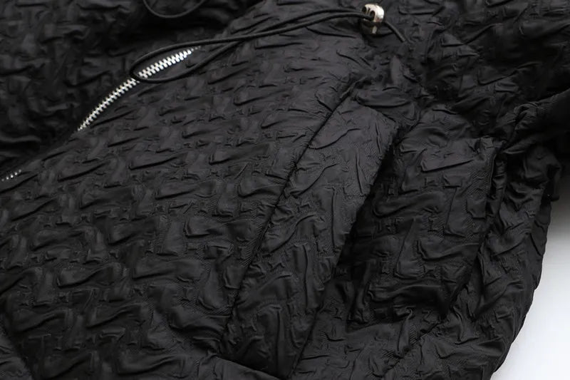 Schwarze gesteppte Jacke mit Reißverschluss, strukturierte Oberfläche, modisch, warm.