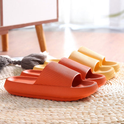 Orange und gelbe Badeschlappen auf Teppich, rutschfest, bequem, für Zuhause.