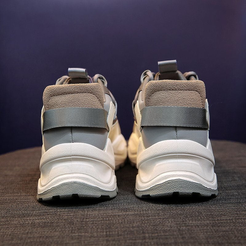 Weiße und graue Sneaker, Rückansicht, auf grauem Hintergrund, modische Sportschuhe.