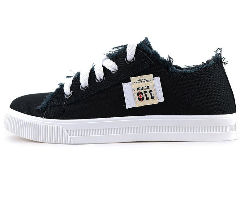 Schwarzer Sneaker aus Denim mit weißen Schnürsenkeln und Gummisohle, lässiger Freizeitschuh.