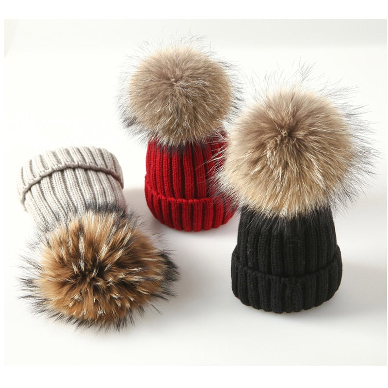 Drei Strickmützen mit Fellbommel, rot, schwarz, beige, Wintermode Accessoire, warm, stilvoll.