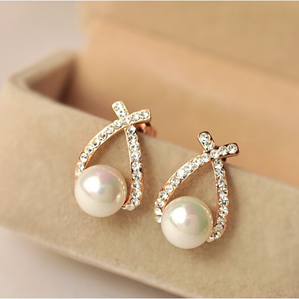 Goldene Ohrringe mit Perlen und Strasssteinen, eleganter Schmuck, Damenaccessoire.