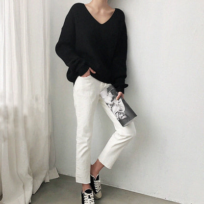 Frau in schwarzem Pullover und weißer Hose, lässiger Look, Modefotografie, minimalistisch.