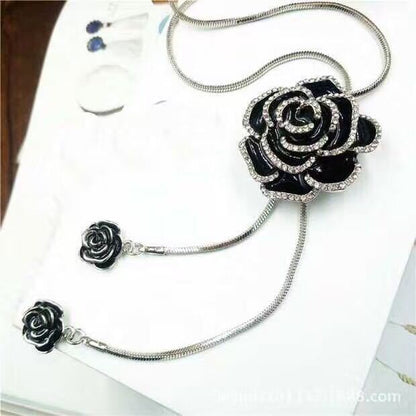 Schwarze Rosenbrosche mit Strass, elegantes Schmuckstück, silberne Kette, modisches Accessoire.