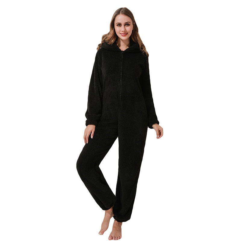 Frau in schwarzem Fleece-Overall mit Kapuze, gemütliche Damenbekleidung, Ganzkörperanzug.
