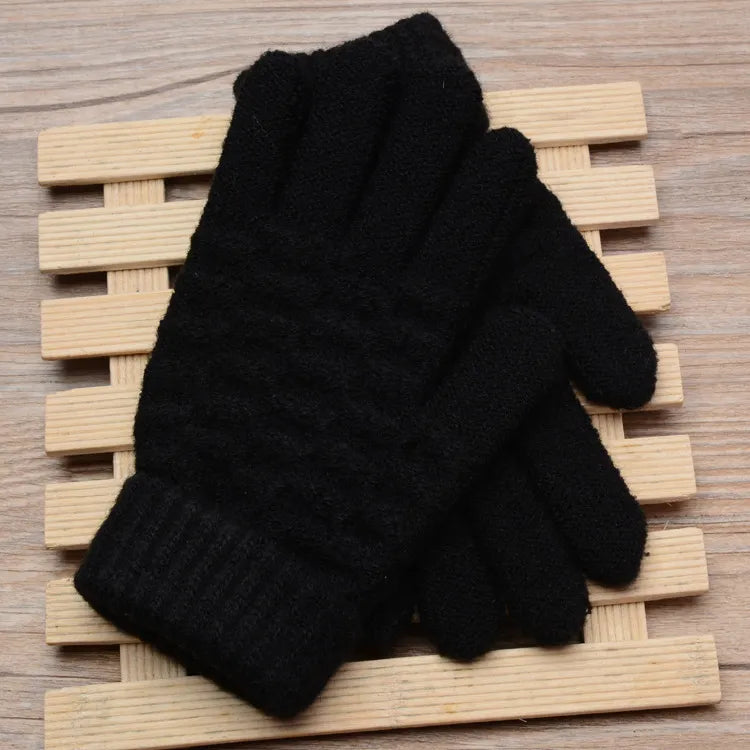 Schwarze gestrickte Winterhandschuhe auf Holzunterlage, warm und stilvoll.