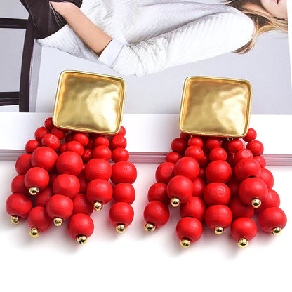 Goldene Ohrringe mit roten Perlen, modisch, auffällig, Schmuck für Damen, elegant.