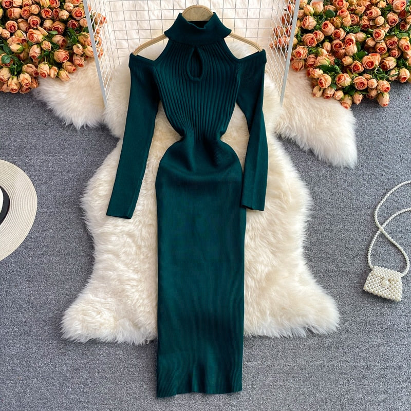 Grünes Strickkleid mit Schulterfrei-Design auf weißem Fellteppich, elegantes Damenmode-Outfit.