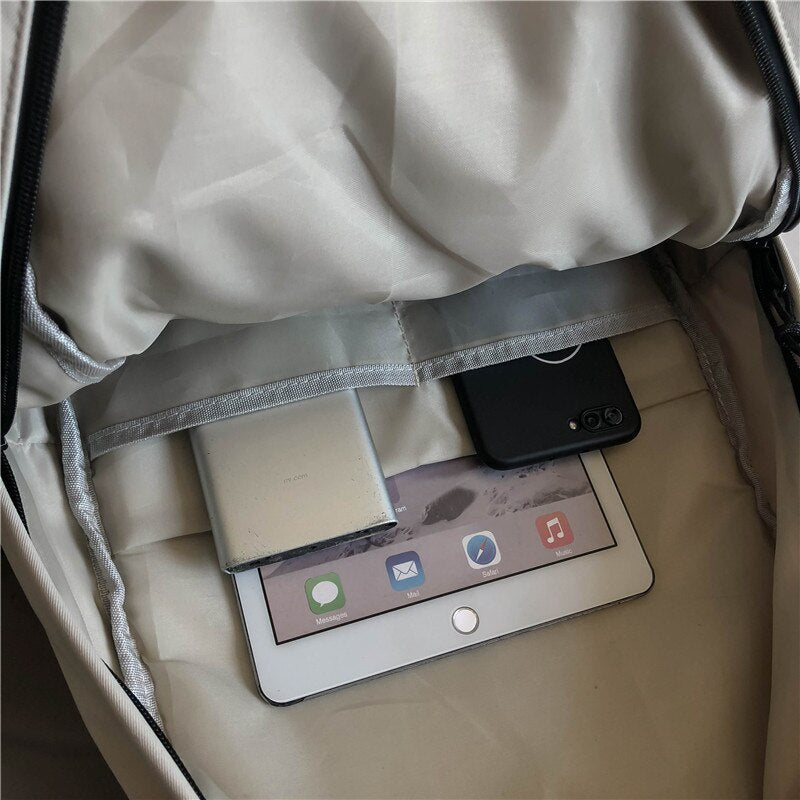 Innenansicht Rucksack mit Tablet, Smartphone und Powerbank, beige, geräumig, praktisch für Reisen.