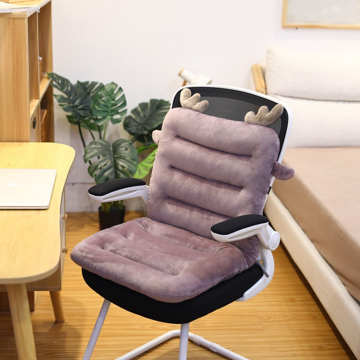 Bürostuhl mit lila Plüschkissen und Rentiergeweih, ergonomisch, modernes Design, Holzfußboden.
