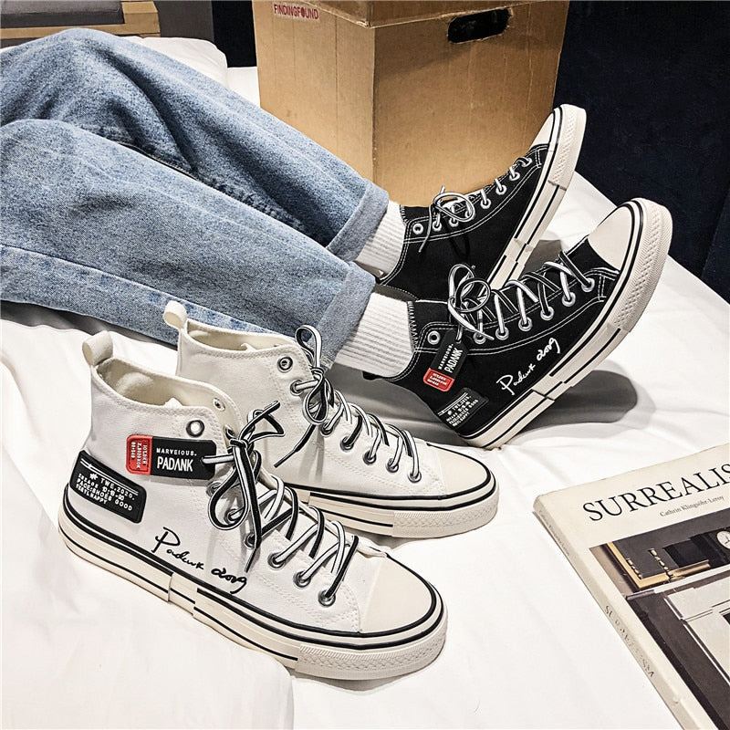 Schwarz-weiße High-Top-Sneaker, Unisex, mit Schriftzug, lässig, modisch, auf weißem Hintergrund.