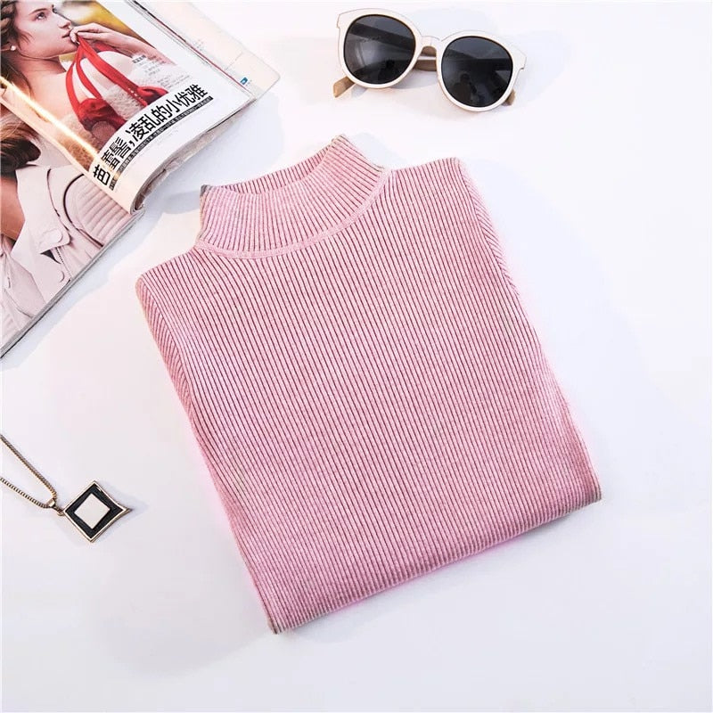 Rosa Rollkragenpullover aus Strick, Damenmode, gefaltet, neben Sonnenbrille und Magazin.