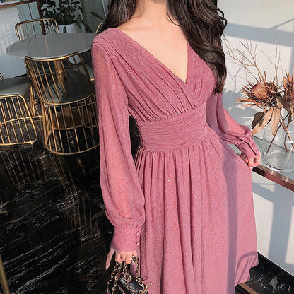 Frau in rosa Abendkleid mit V-Ausschnitt, elegantes Design, langärmlig, modisch.