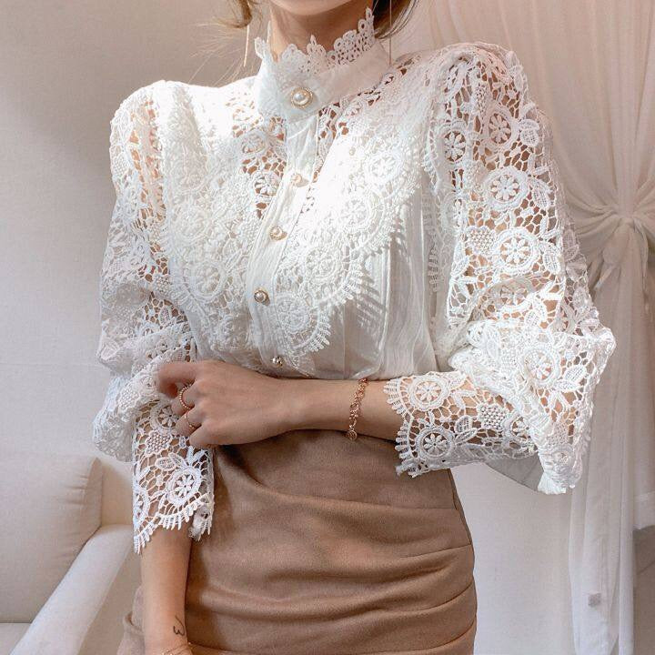 Damenbluse aus weißer Spitze mit Stehkragen und Knopfleiste, elegant und modisch.