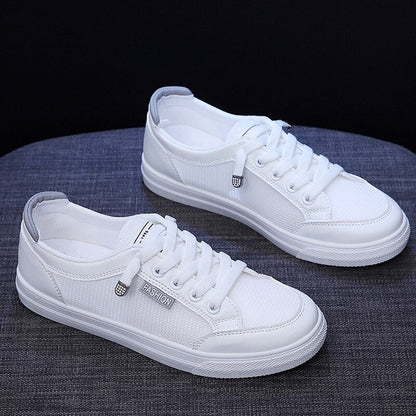 Weiße Sneaker aus Canvas, Unisex, modisch, lässig, mit Schnürsenkeln, auf grauem Hintergrund.