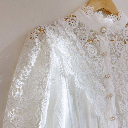 Weiße Spitzenbluse mit Perlenknöpfen, elegantes Design, Damenmode, Vintage-Stil.