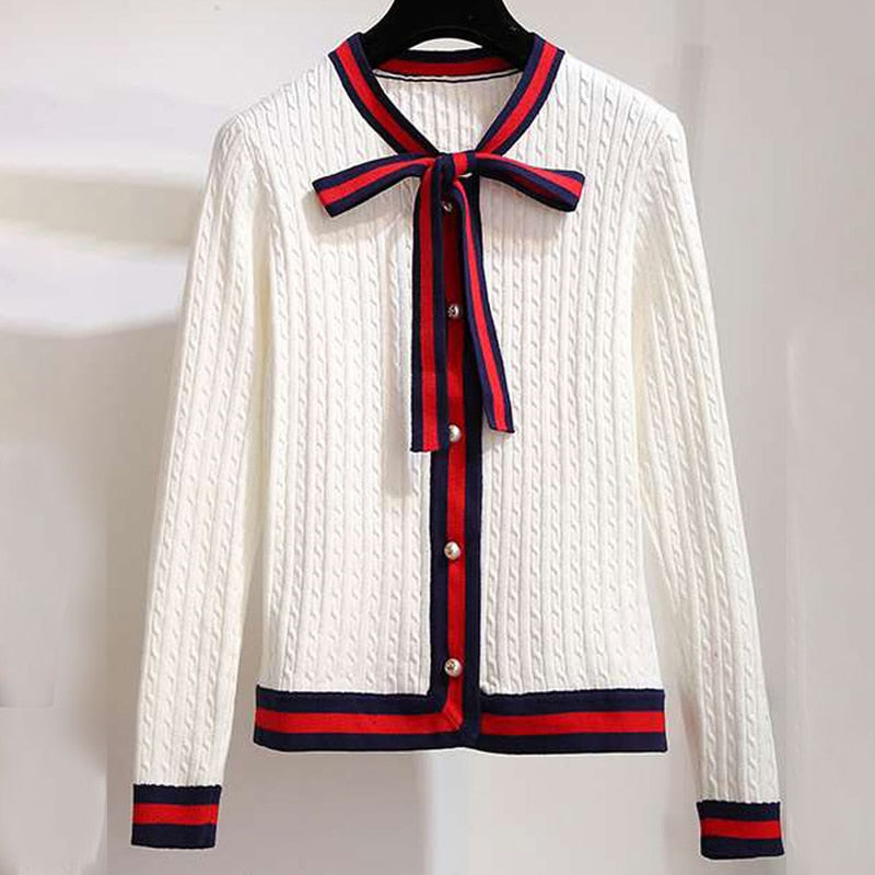 Weiße Strickjacke mit roten und blauen Streifen, Knopfleiste und Schleife, Damenmode.