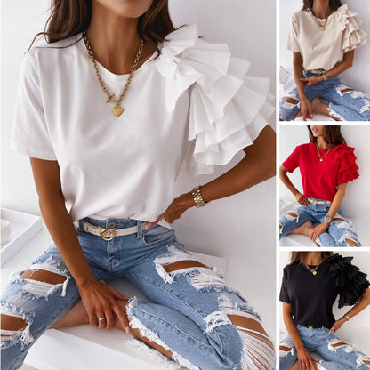 Frau trägt weißes T-Shirt mit Rüschenärmel, zerrissene Jeans, modisches Outfit, Damenmode.