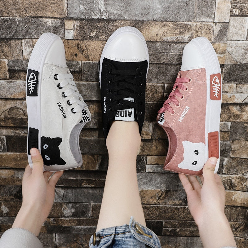 Drei Paar Sneakers mit Tiermotiven, in Weiß, Schwarz und Rosa, auf Steinboden.