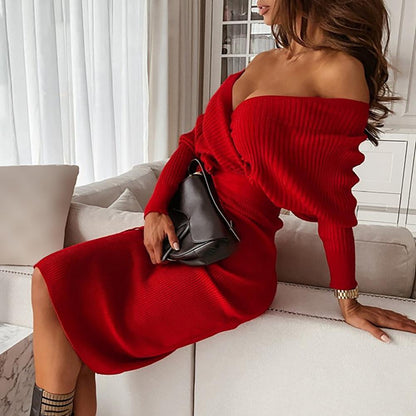 Frau in rotem Strickkleid, schulterfrei, mit schwarzer Tasche auf Sofa sitzend.