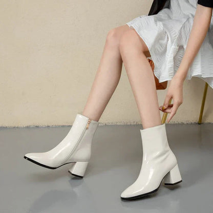 Weiße Damenstiefeletten aus Lackleder mit Blockabsatz, modisch und elegant.