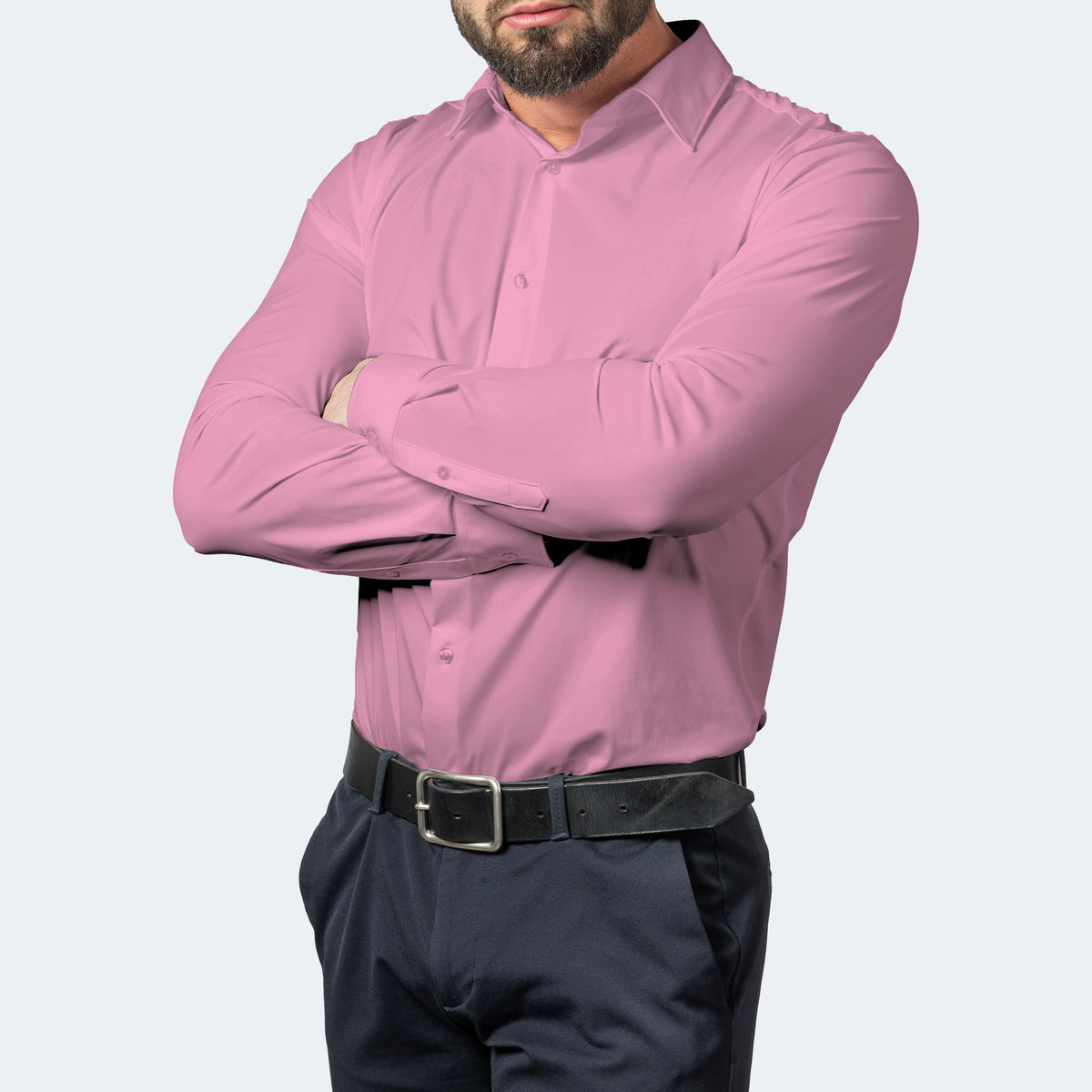 Man i rosa skjorta med korsade armar, kombinerad med mörka byxor och svart skärp 8