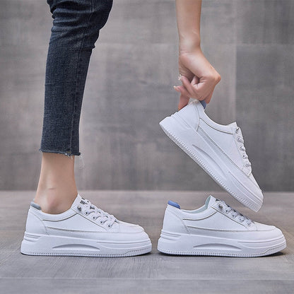 Weiße Sneaker Damen, modisch, bequem, Freizeit, Jeans, grauer Hintergrund.