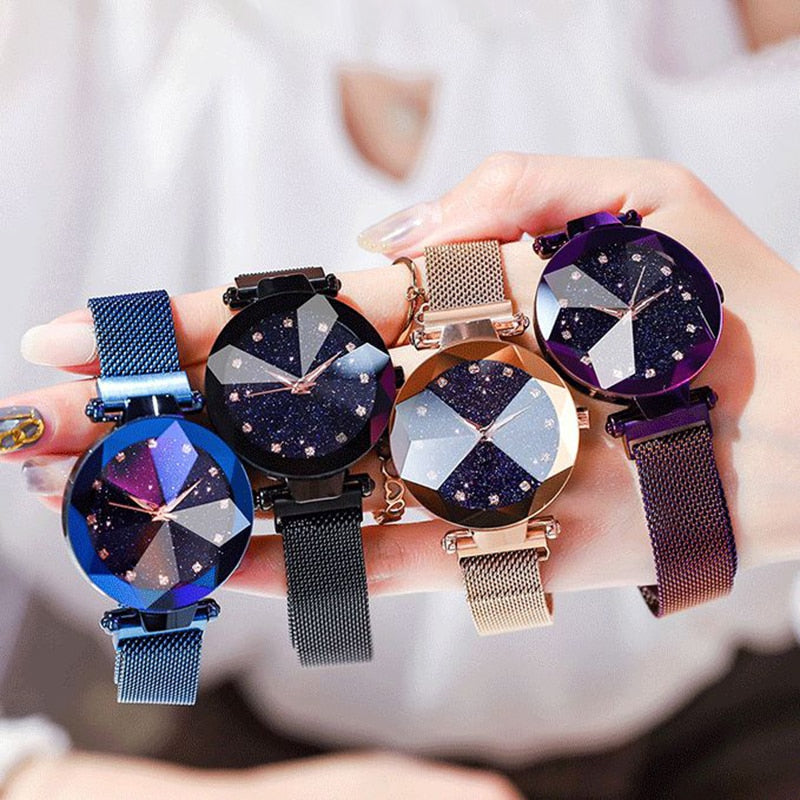 Vier Damenarmbanduhren mit funkelndem Zifferblatt und Metallarmband in verschiedenen Farben.