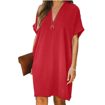 Frau in rotem Sommerkleid mit V-Ausschnitt, braune Clutch, lässiger Stil, modisch.