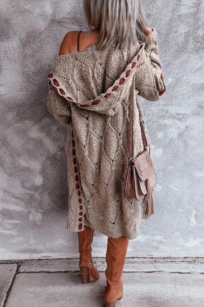 Frau in beigem Strickmantel mit Tasche und Stiefeln, modisch, Herbstmode, Rückansicht.