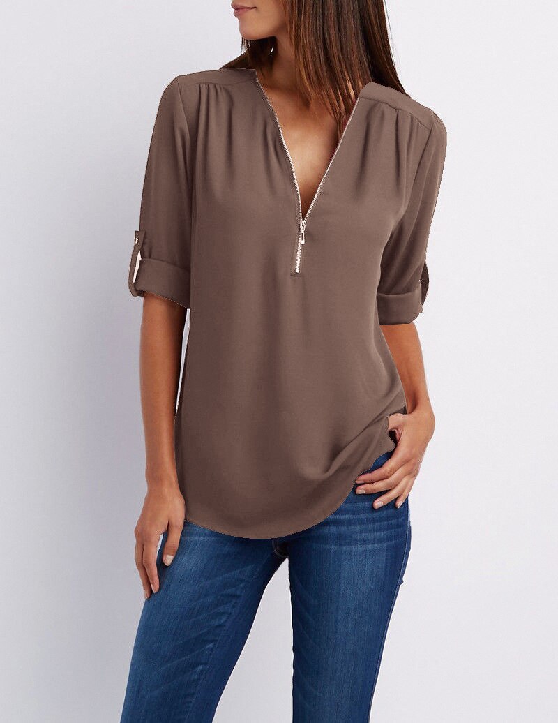 Frau in brauner Bluse mit Reißverschluss und blauen Jeans, lässige Damenmode.