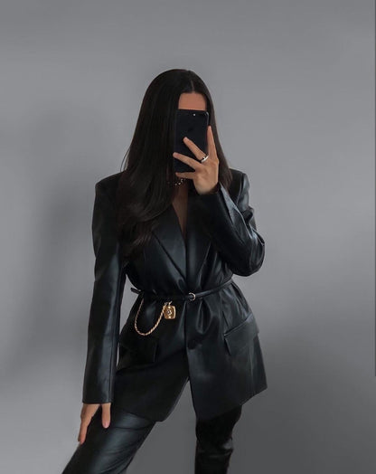 Frau in schwarzem Lederblazer mit Gürtel, Smartphone, Mode, eleganter Look, Damenbekleidung.