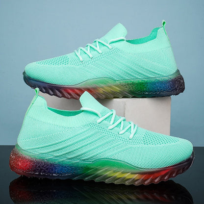 Grüne Sportschuhe mit Regenbogen-Sohle, atmungsaktives Mesh, modisches Design.
