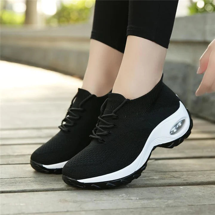Schwarze orthopädische Damen-Wanderschuhe, bequem, atmungsaktiv, auf Holzweg.