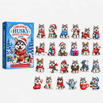 Blå kartongförpackning med en huskyvalp i röd sjal och tomteluva, bredvid de 24 prydnaderna i julmotiv utlagda på rad. 2