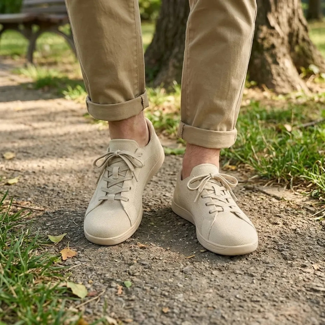 Beige skor i mesh på en person i beige byxor med uppvikta ben, på en parkstig. 2