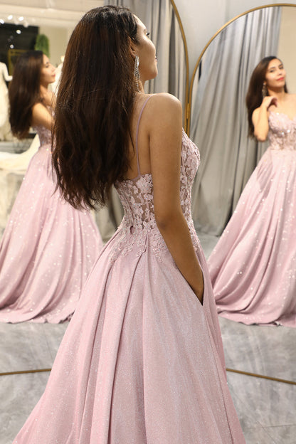 Frau im rosa Abendkleid mit Spitzenoberteil und Spaghettiträgern vor Spiegel.