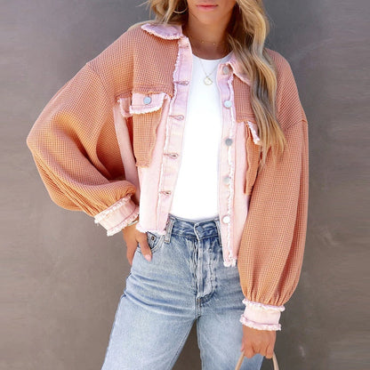 Frau in rosa-beiger Strickjacke, weiße Bluse, Jeans; modische Damenbekleidung.