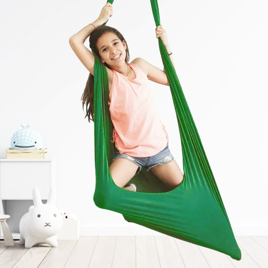 Mädchen in grünem Indoor-Schaukeltuch, ideal für sensorische Therapie und Spielzimmer.