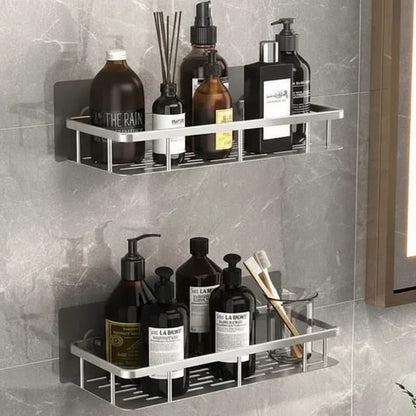 Två silverfärgade hyllor på grå marmorvägg med flaskor, doftpinnar och tandborstar i glas 10